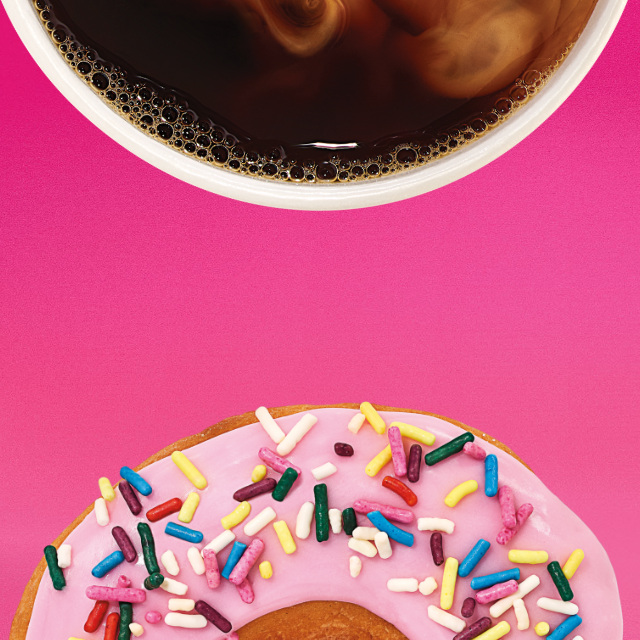 A man drinking a Dunkin' Donuts hot beverage.