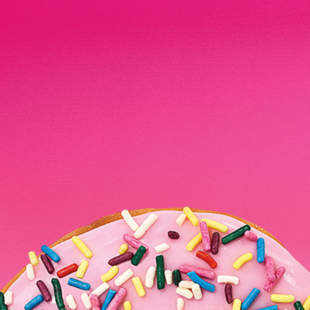 A coffee with cream & A strawberry frosted donut with sprinkles