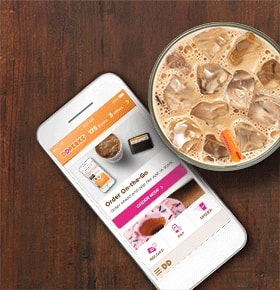 The Dunkin Donuts Mobile App Open On A Wood Table Next To An Iced